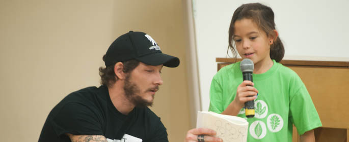 Pictured is a Point Park student reading a poem with an elementary student | photo by Chris Rolinson