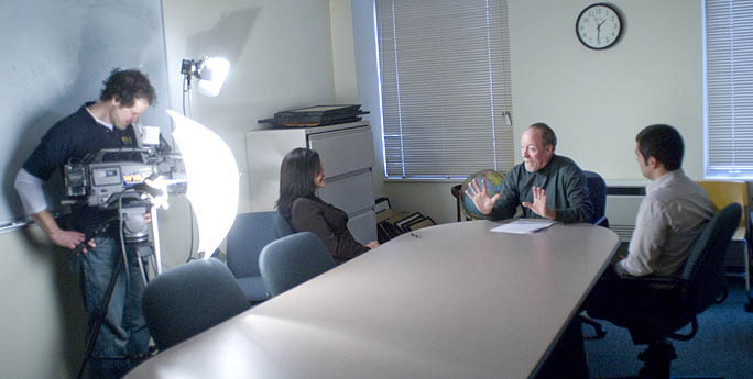 A TV reporter interviews Associate Professor Bill Moushey and alumnus James Keaney about the Ernie S