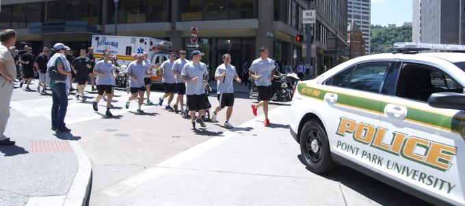 Photo of Point Park police officers and the patrol car participating in the 3rd Annual Be a Fan Torch Run for Special Olympics.