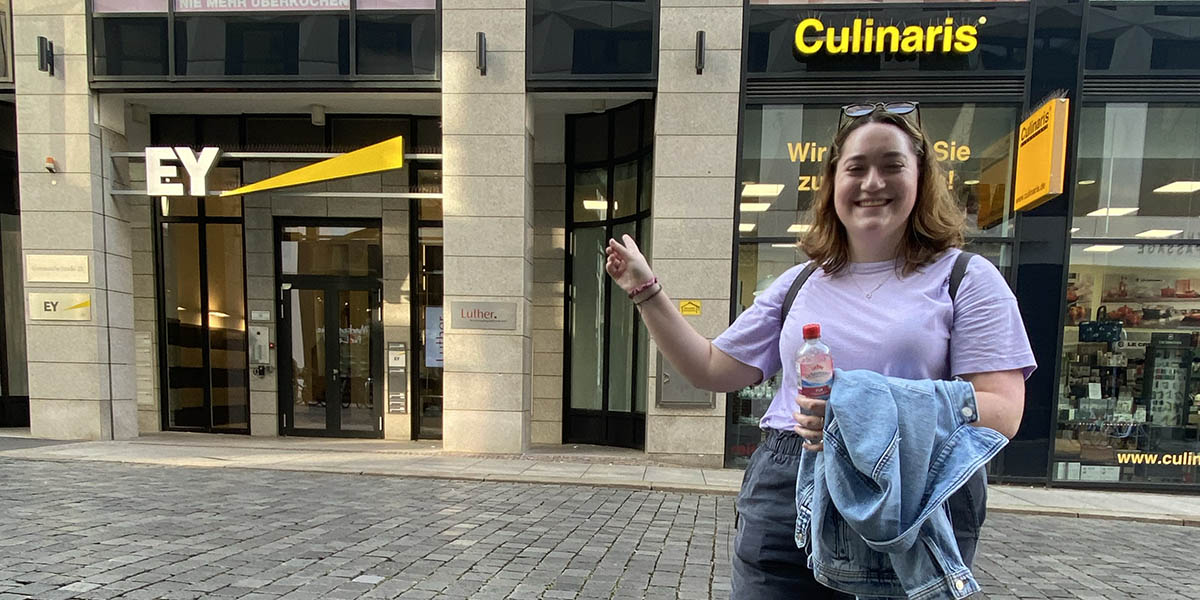 Erin Yudt poses for a photo outside of a building in Leipzig with her initials on it. 