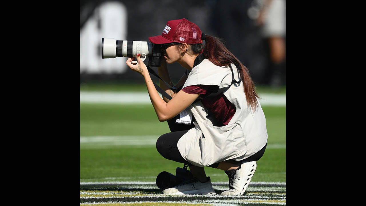 Pictured is Emilee Fails photographing an NFL game.