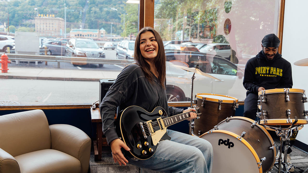 SAEM major Lydia Zarefoss '26 and accounting major Terry Craig Jr. '26 enjoy an impromptu jam session in The Sound Vault, the campus headquarters for Point Park's student-run record label, Pioneer Records. Photo by Ethan Stoner '25. 