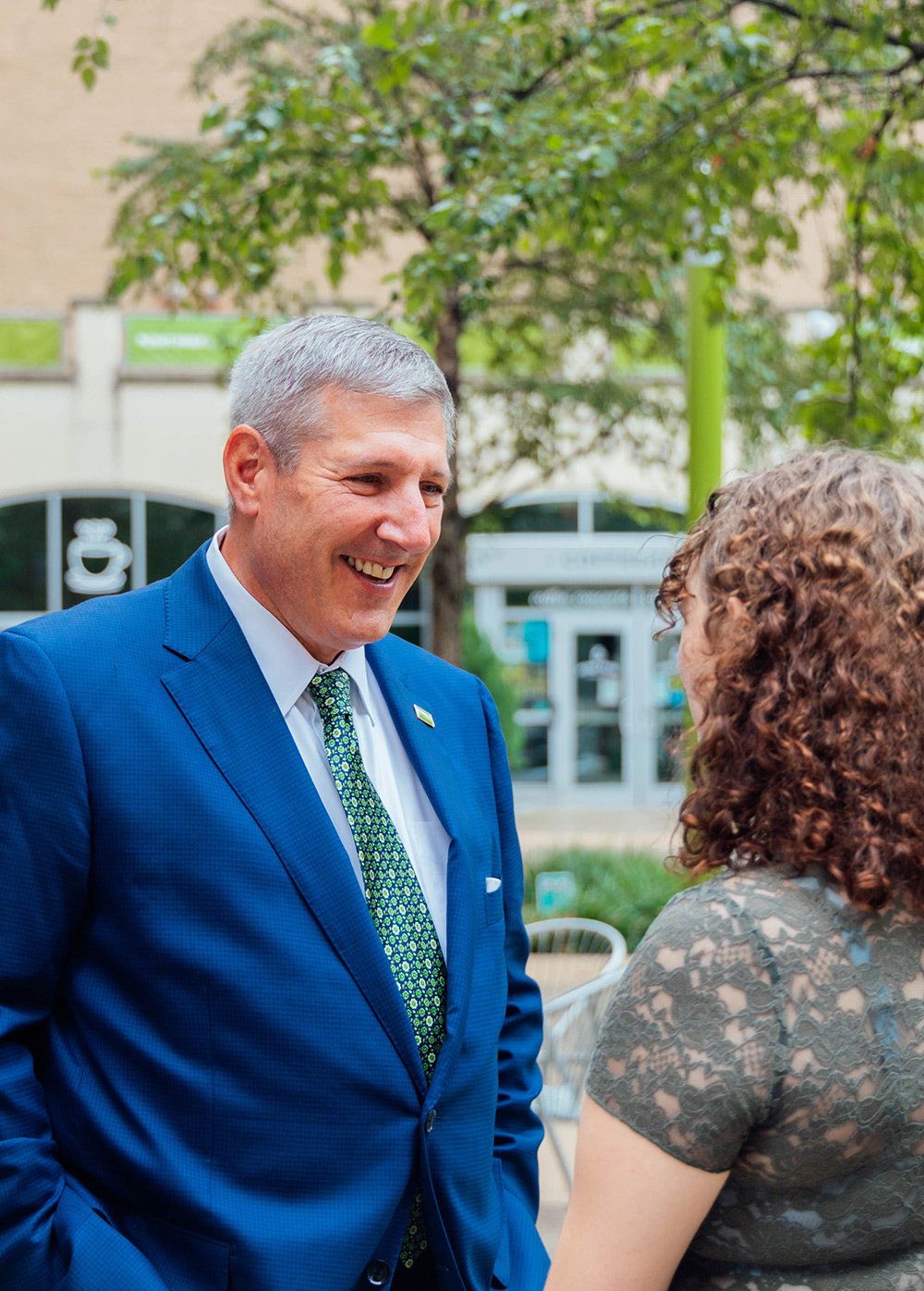 President Brussalis speaking with a student in Village Park. 