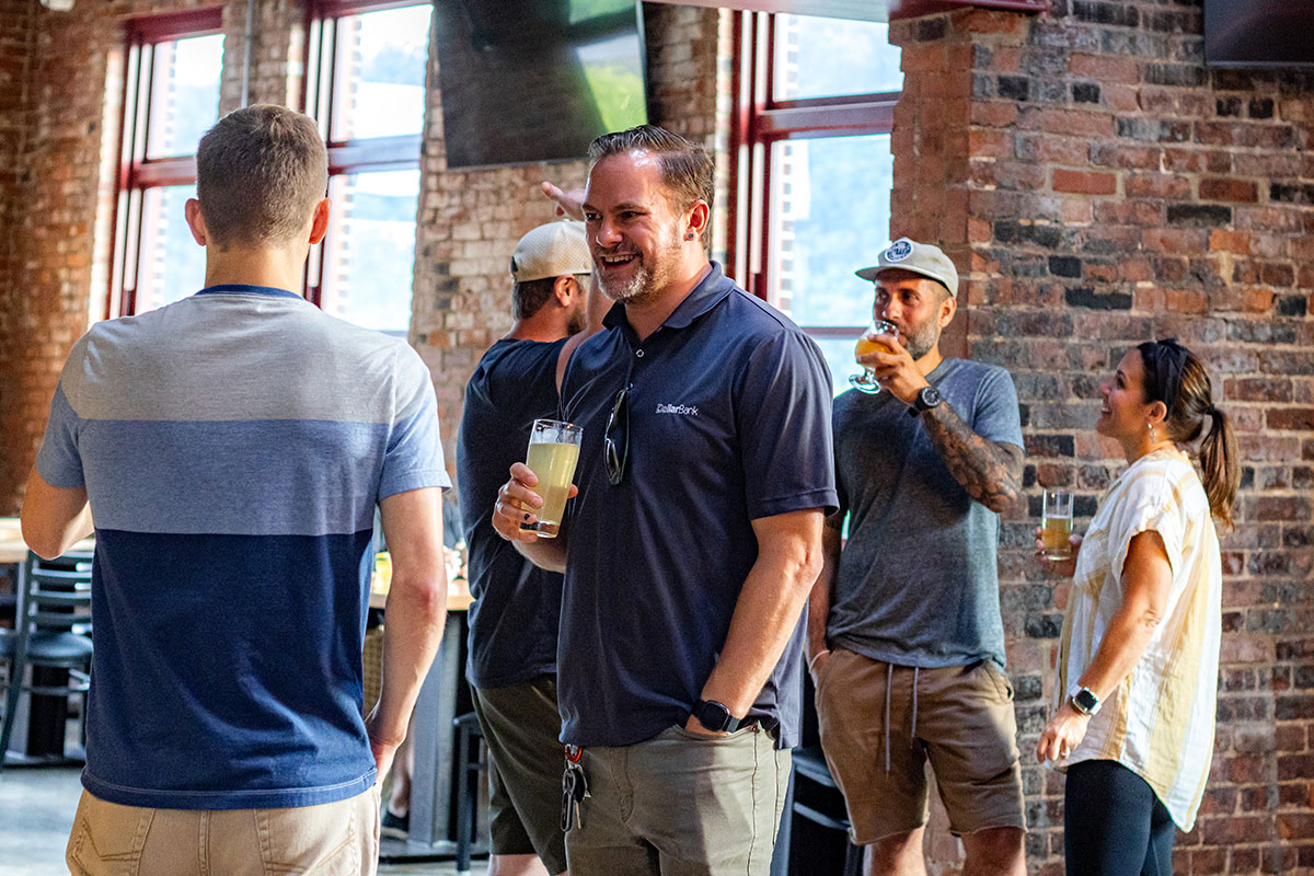 People stand in a restaurant drinking beer.