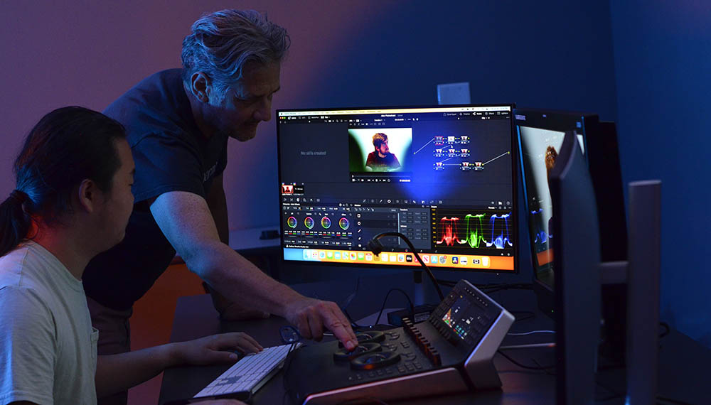 Andrew Halasz works in a film and animation edit bay with a student.