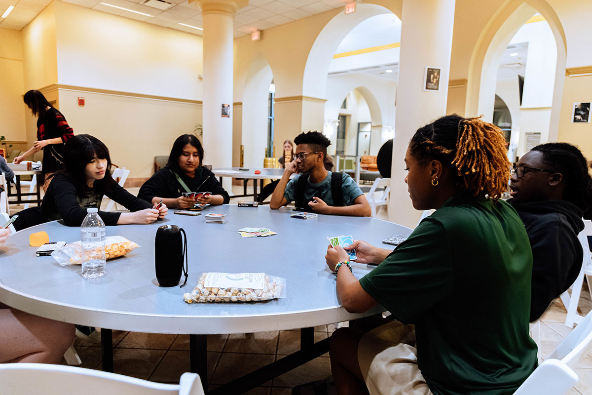 Students play a game around a table.