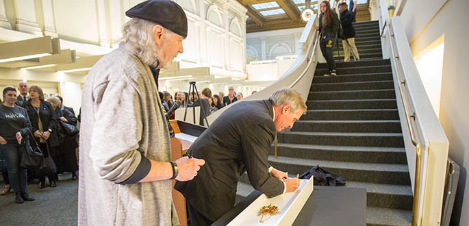 Ronald Lindblom and President Paul Hennigan sign the final beam for Point Park University's new Pittsburgh Playhouse Nov. 30. Photo | John Altdorfer