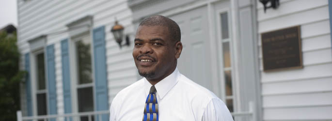 Pictured is criminal justice alumnus Chris Ingram standing outside of The Tom Rutter House on Gateway Rehab's main campus.