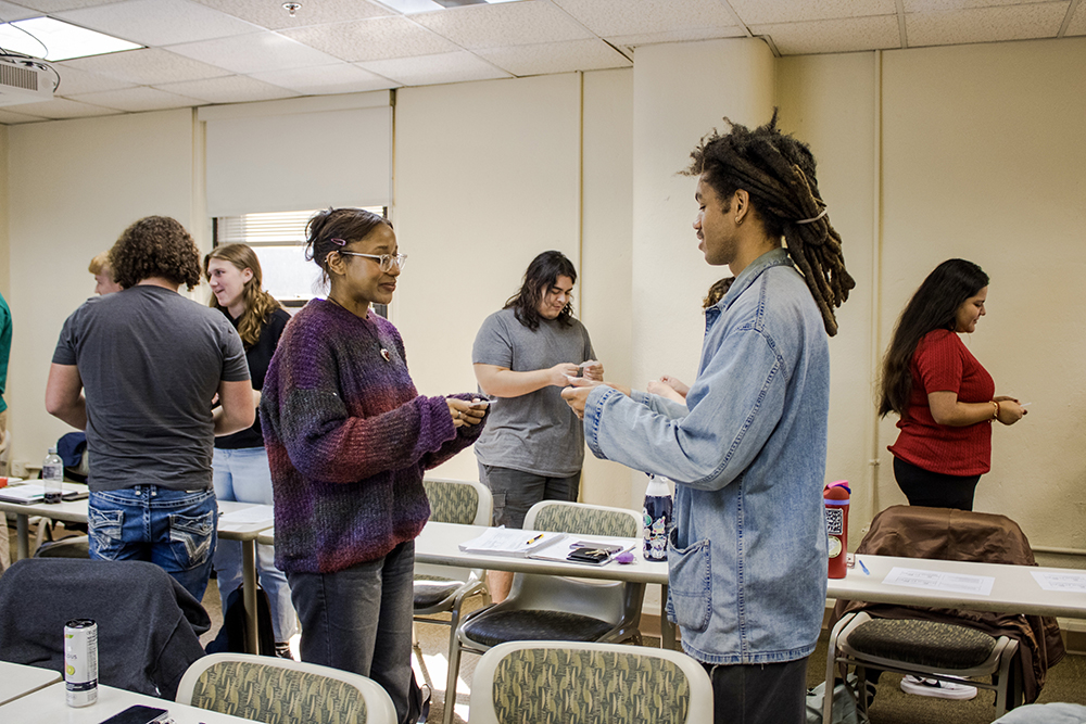 Pictured are students exchanging business cards in the Japanese Culture course. Photo by Nadia Jones '25.