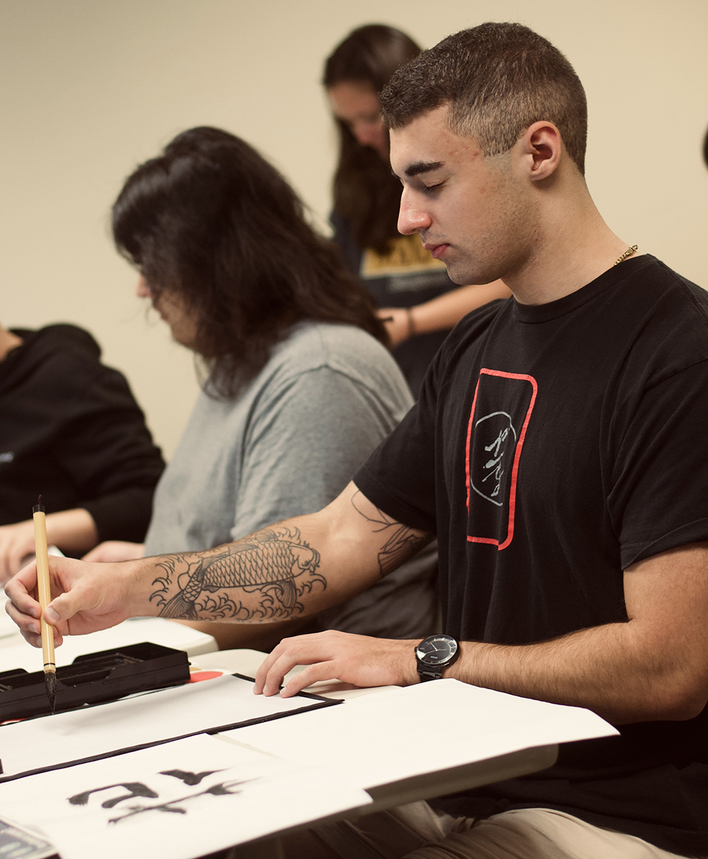 Pictured is Ryan Milazzo doing calligraphy. Photo by Rosita Grigaite.