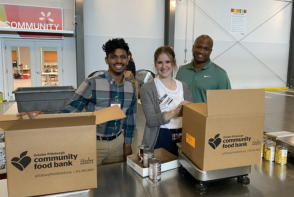 Pictured are students Esrom Williams, Margaret Hinnebusch and Leroy Headen at the Greater Pittsburgh Community Food Bank. Photo by Nicole Chynoweth.