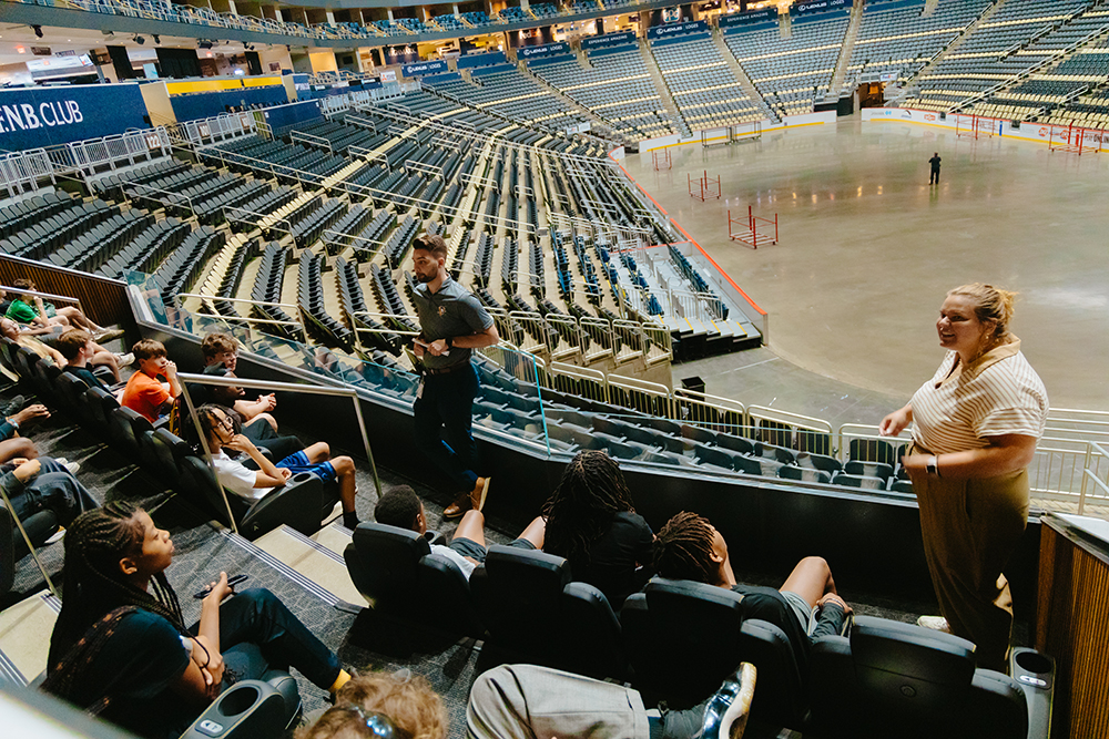 Pictured are Pittsburgh Penguins employees speaking to students inside PPG Paints Arena during Sports Business Camp. Photo by Ethan Stoner.