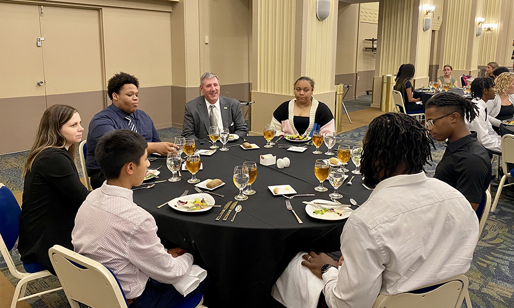 President Chris Brussalis interacts with ACAP students during the camp's etiquette dinner. Photo by Nicole Chynoweth.
