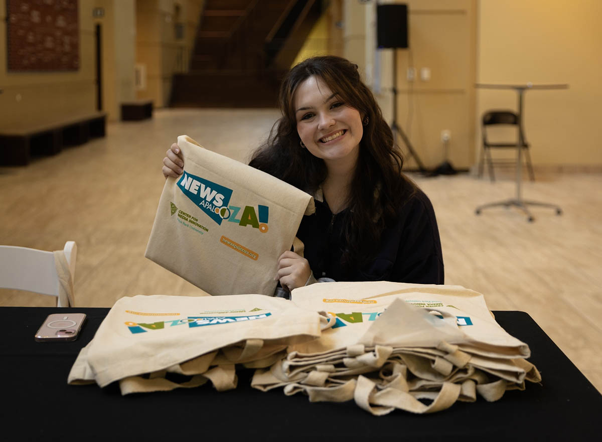 A Point Park student shows off Newsapalooza bags.