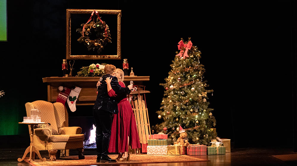 Joe and Kristin Serafini sharing a hug onstage during Christmas Live! with Joe Serafini and Friends.