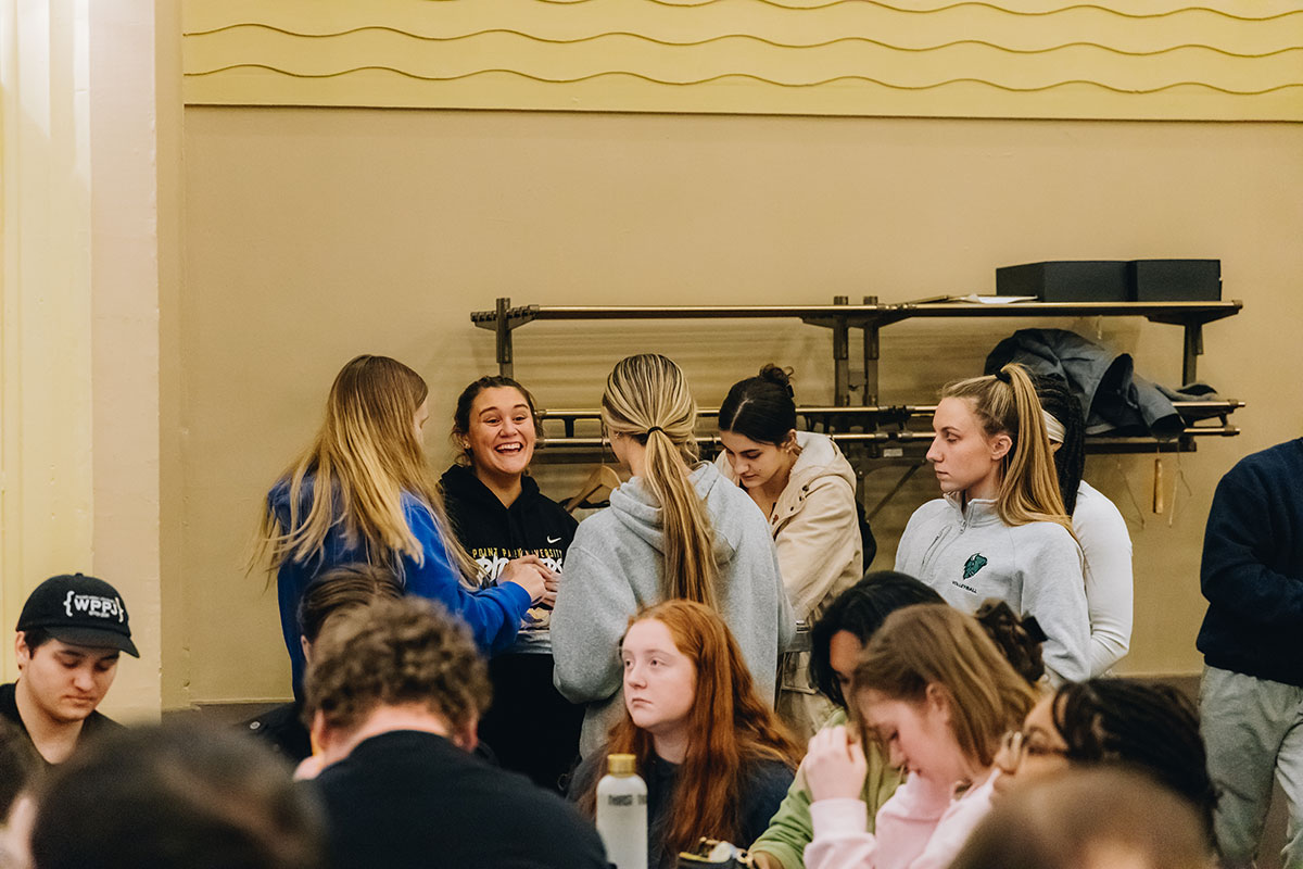 Students laugh at a table playing bingo. 