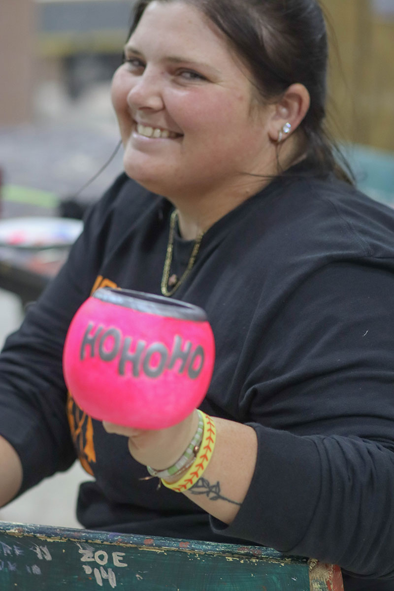 A student holds up a ceramic mug.