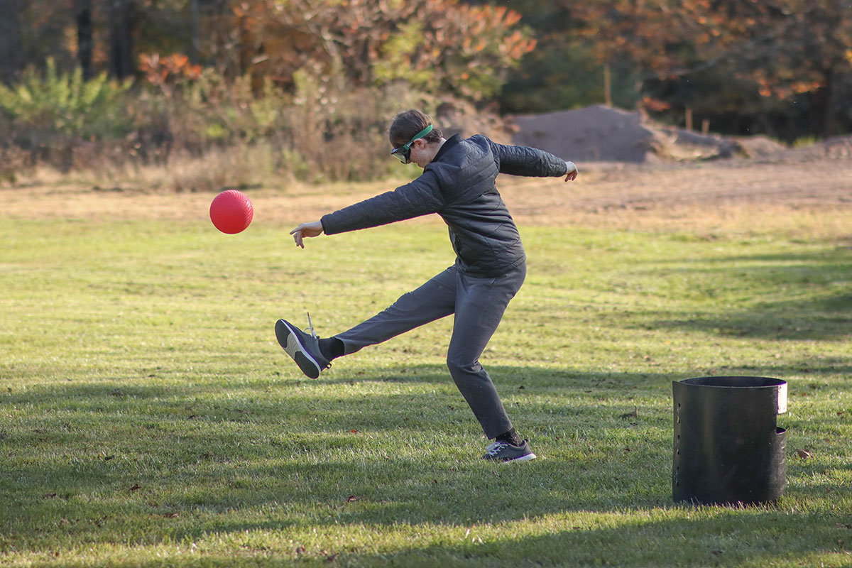 Students wearing goggles play kickball.