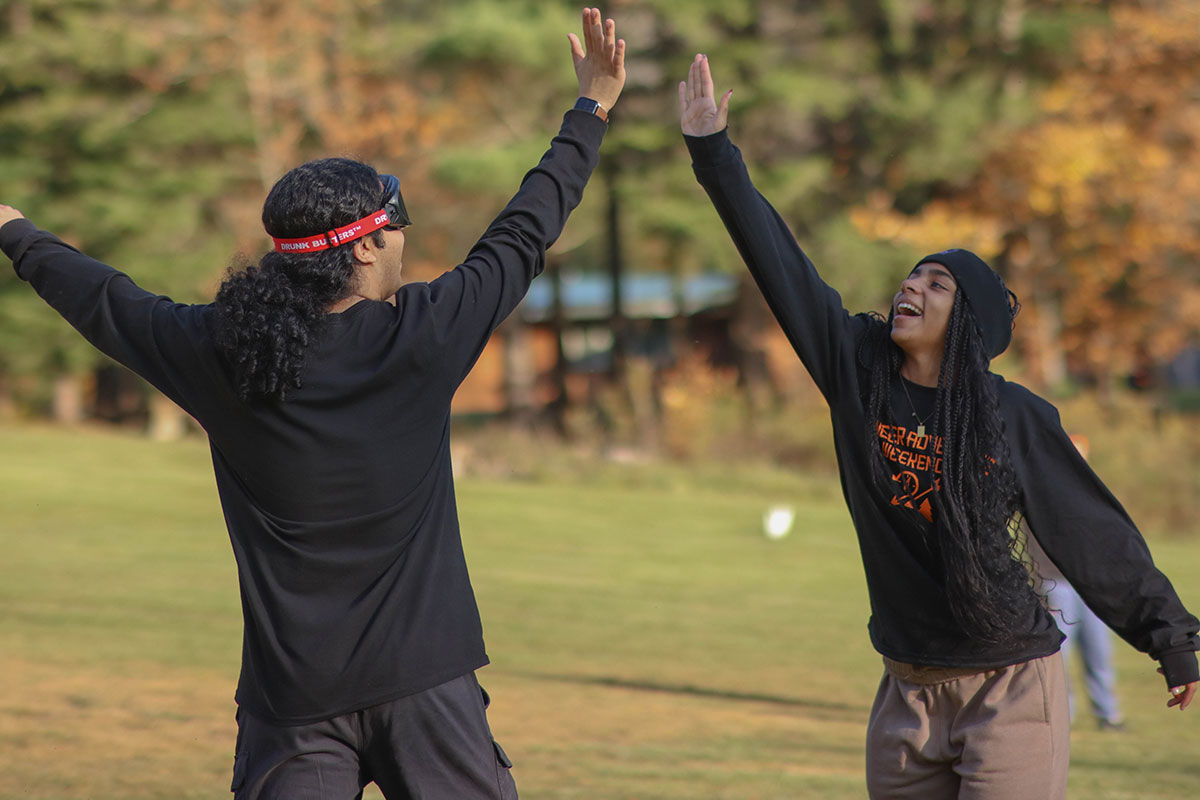 Students wearing goggles play kickball.