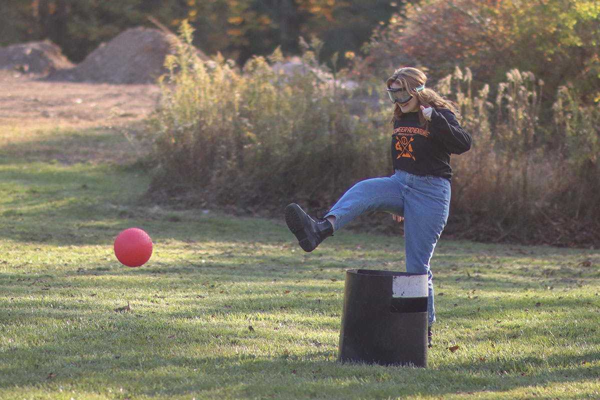 Students wearing goggles play kickball.