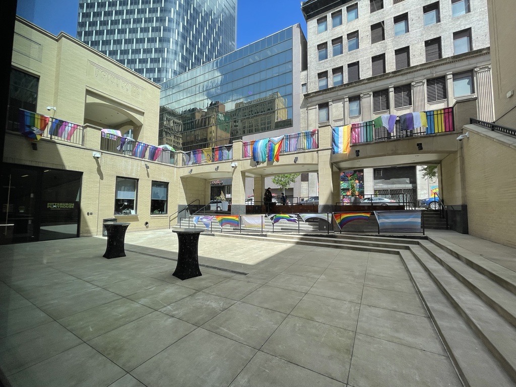 A courtyard is decorated in rainbow flags