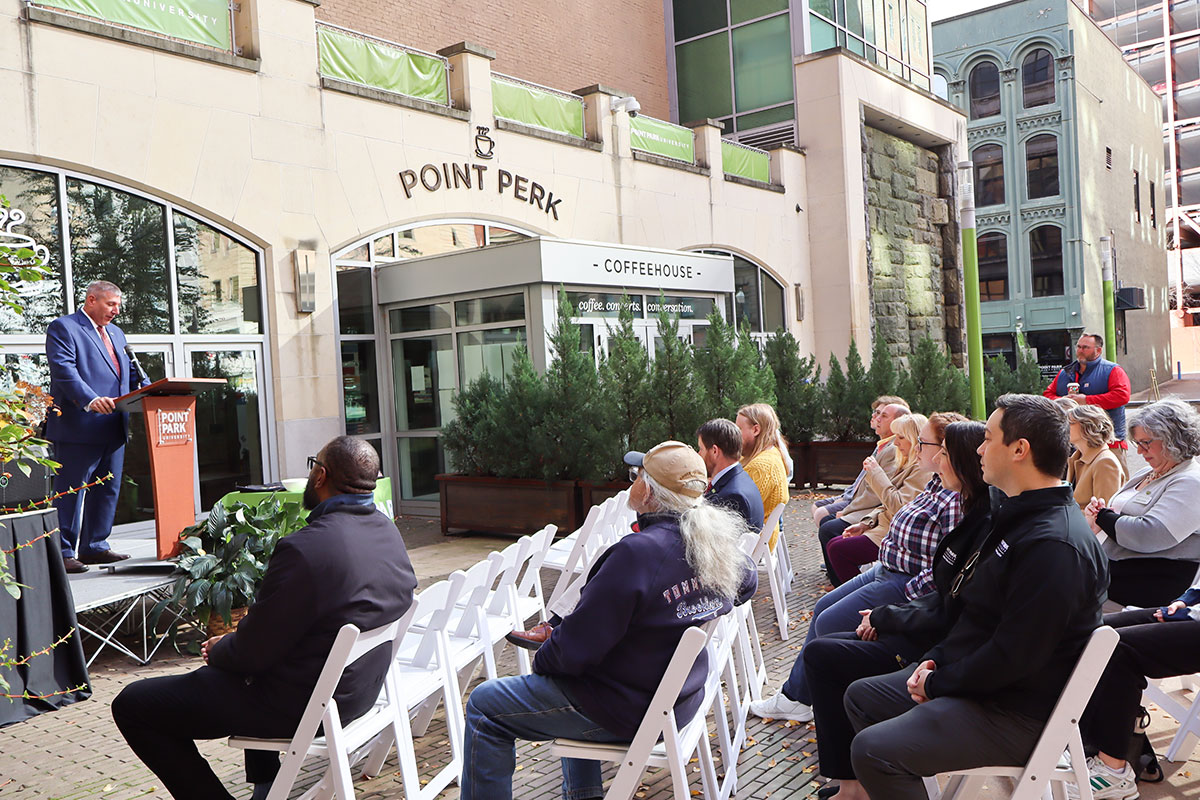 A group of people sit in white chairs. 