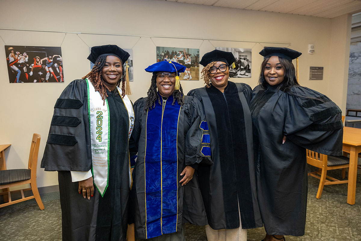 Four graduates pose for a photo.