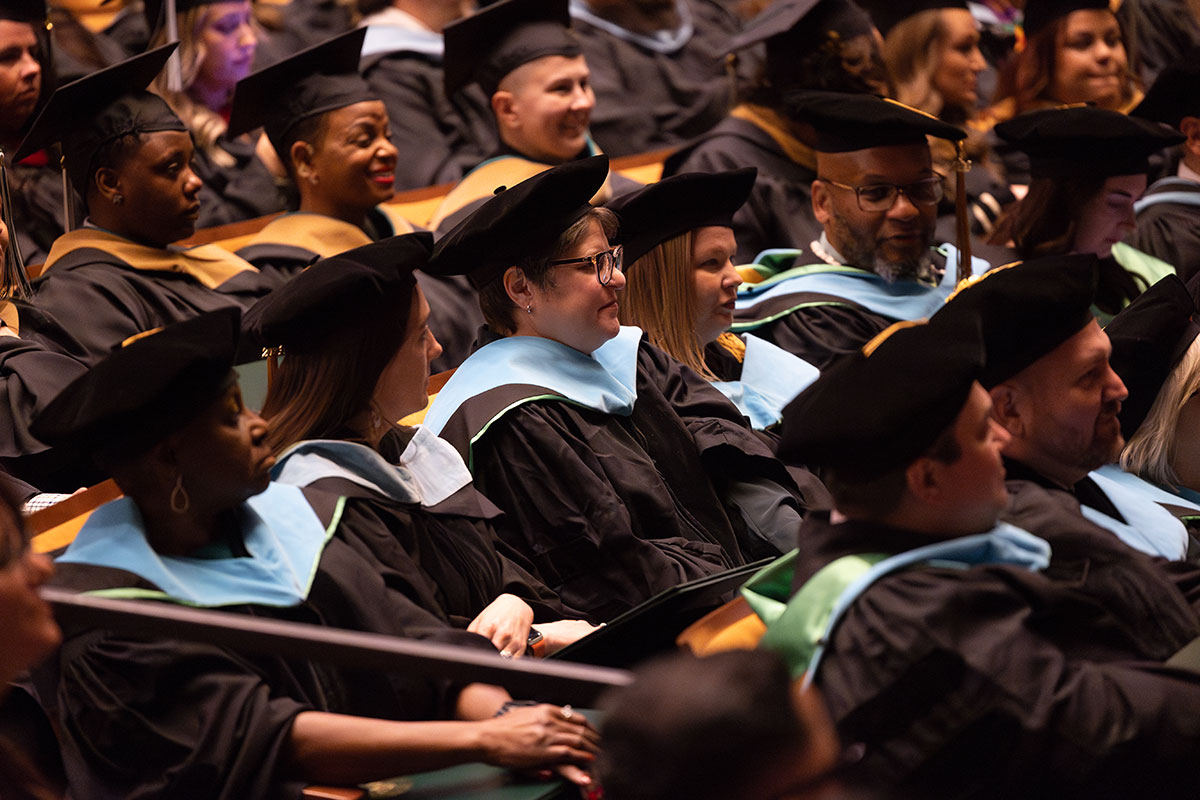 Graduates sit in seats. 