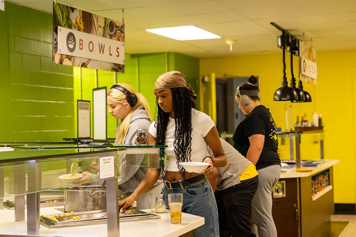 Students select food in the dining room buffet.